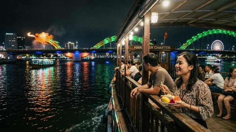 Night cruise boat passing the illuminated Dragon Bridge on a Han River cruise in Da Nang, Vietnam